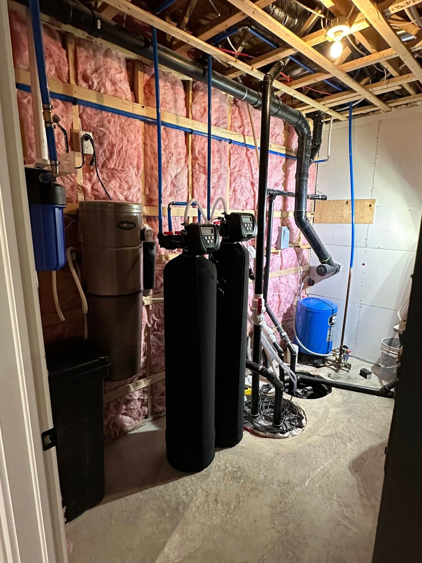 Water treatment equipment room with water softeners and filtration installed by ERSA Plumbing