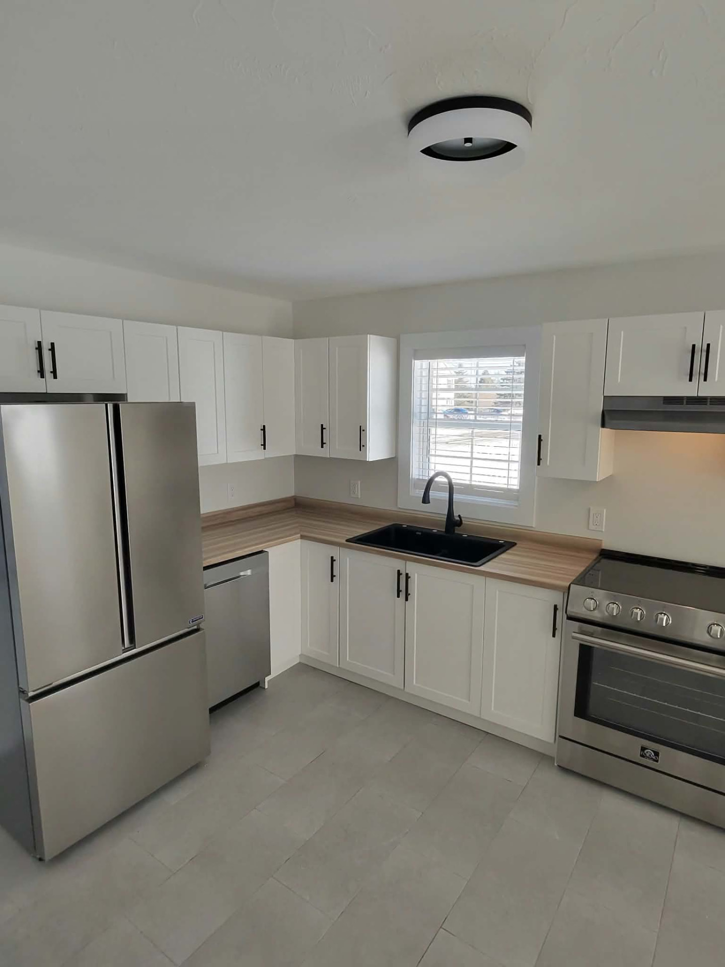 Finished kitchen with a black sink, faucet and dishwasher plumbing installed by ERSA Plumbing