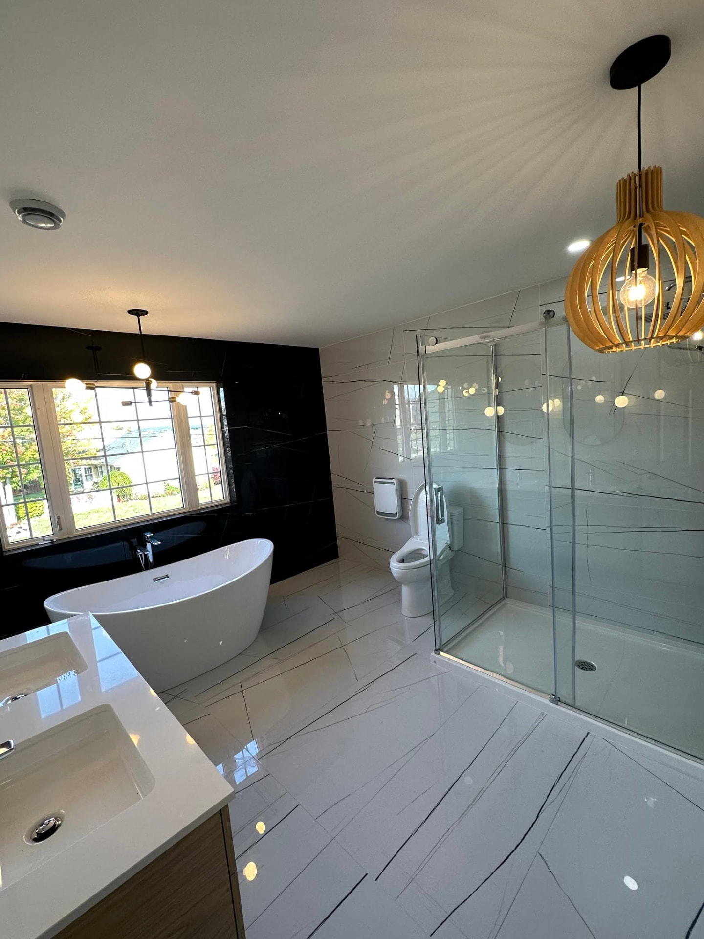 Finished bathroom with a glass walk-in shower and freestanding tub installed by ERSA Plumbing