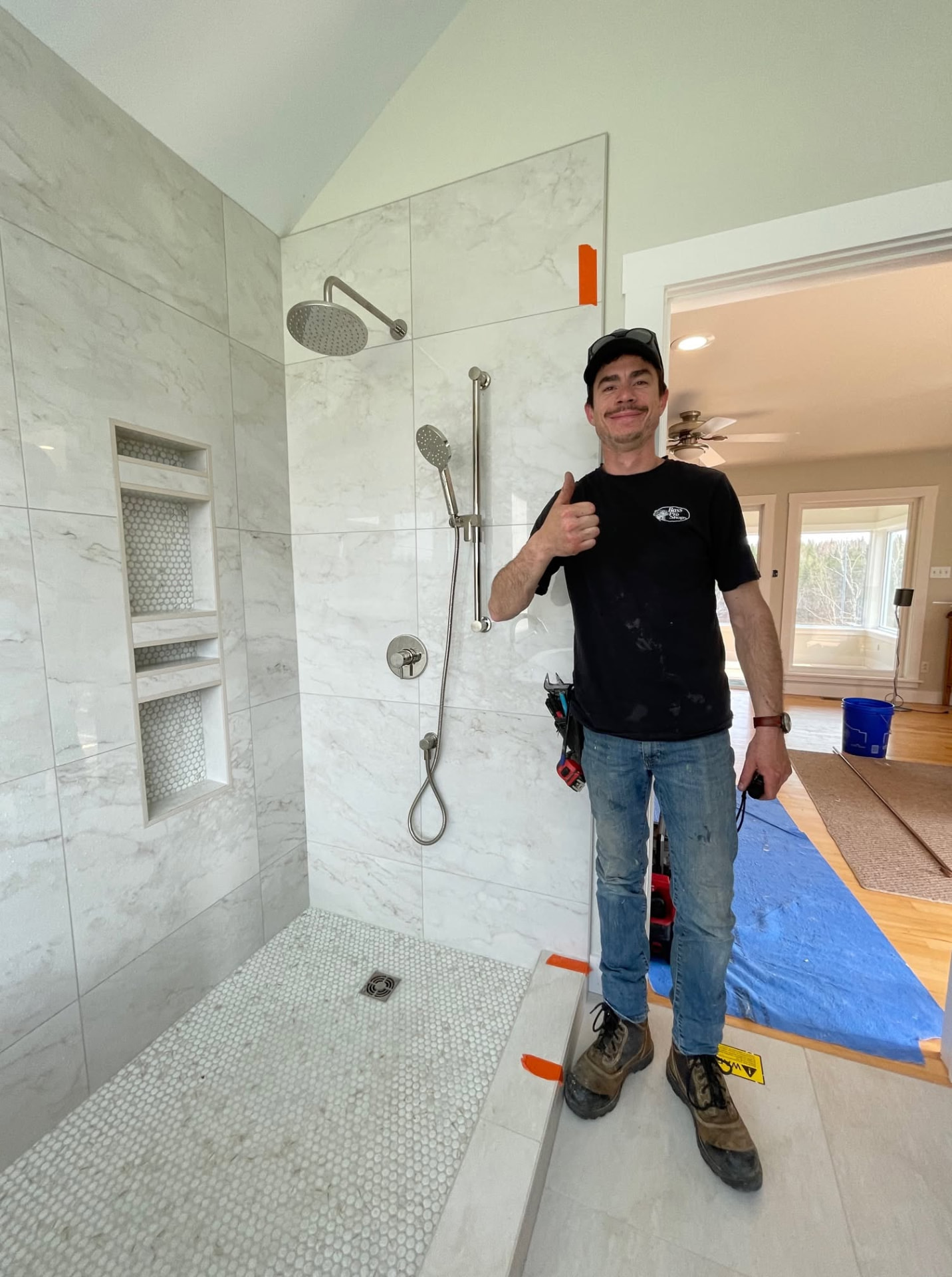 Eric Saucier beside a completed custom shower installation