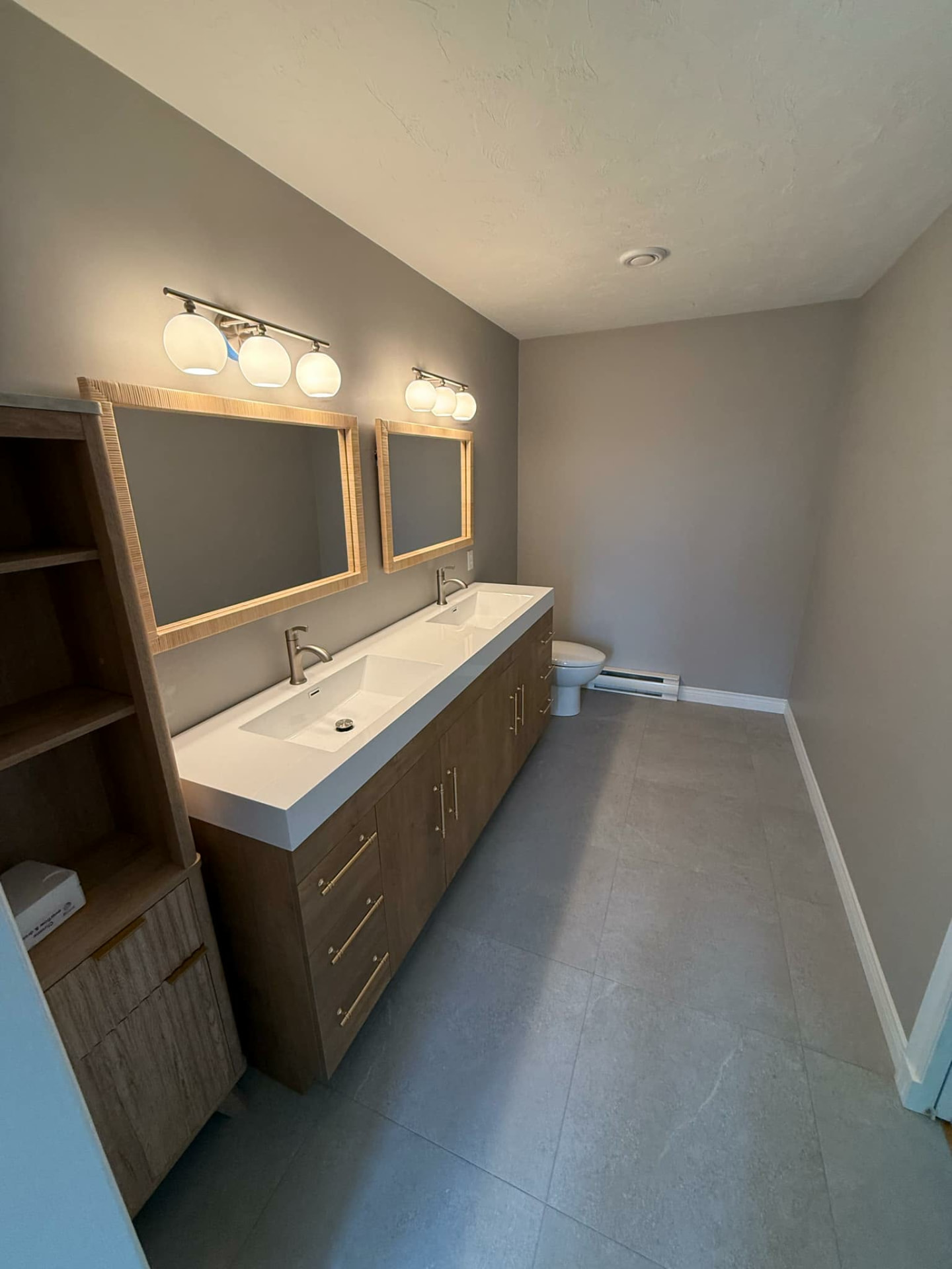 Double-sink vanity with light wood cabinetry and plumbing installed by ERSA Plumbing