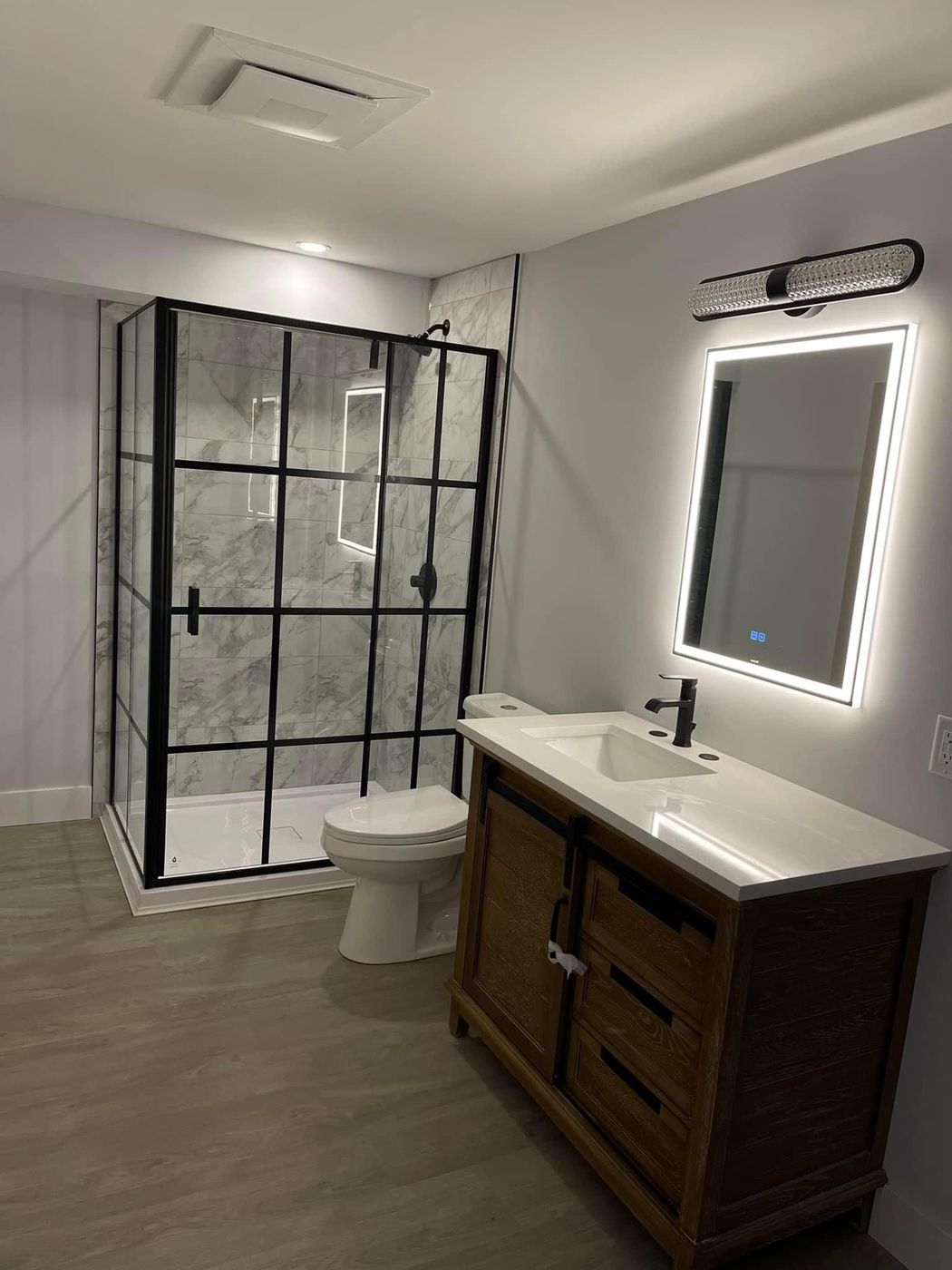 Completed bathroom with glass shower and vanity plumbing