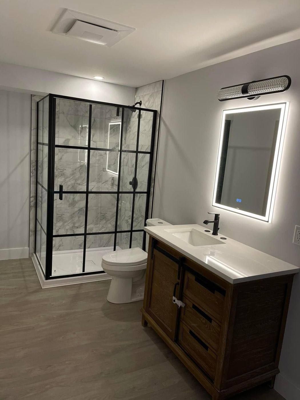 Completed bathroom with glass shower and vanity plumbing