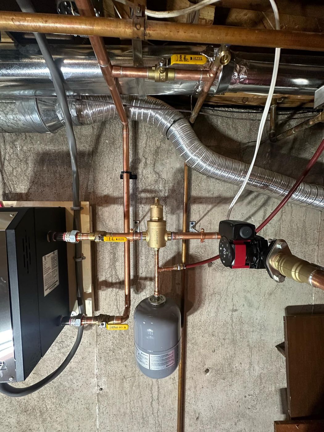 Neatly piped mechanical room with copper lines and boiler controls