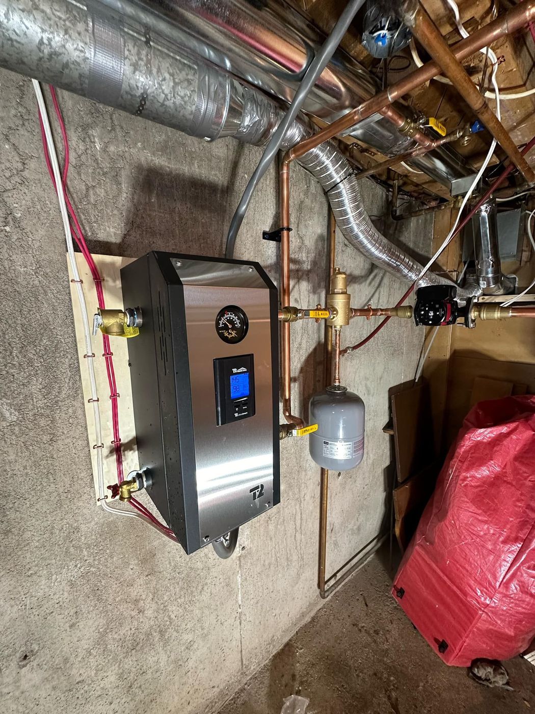 Boiler and copper distribution piping installed in a utility room