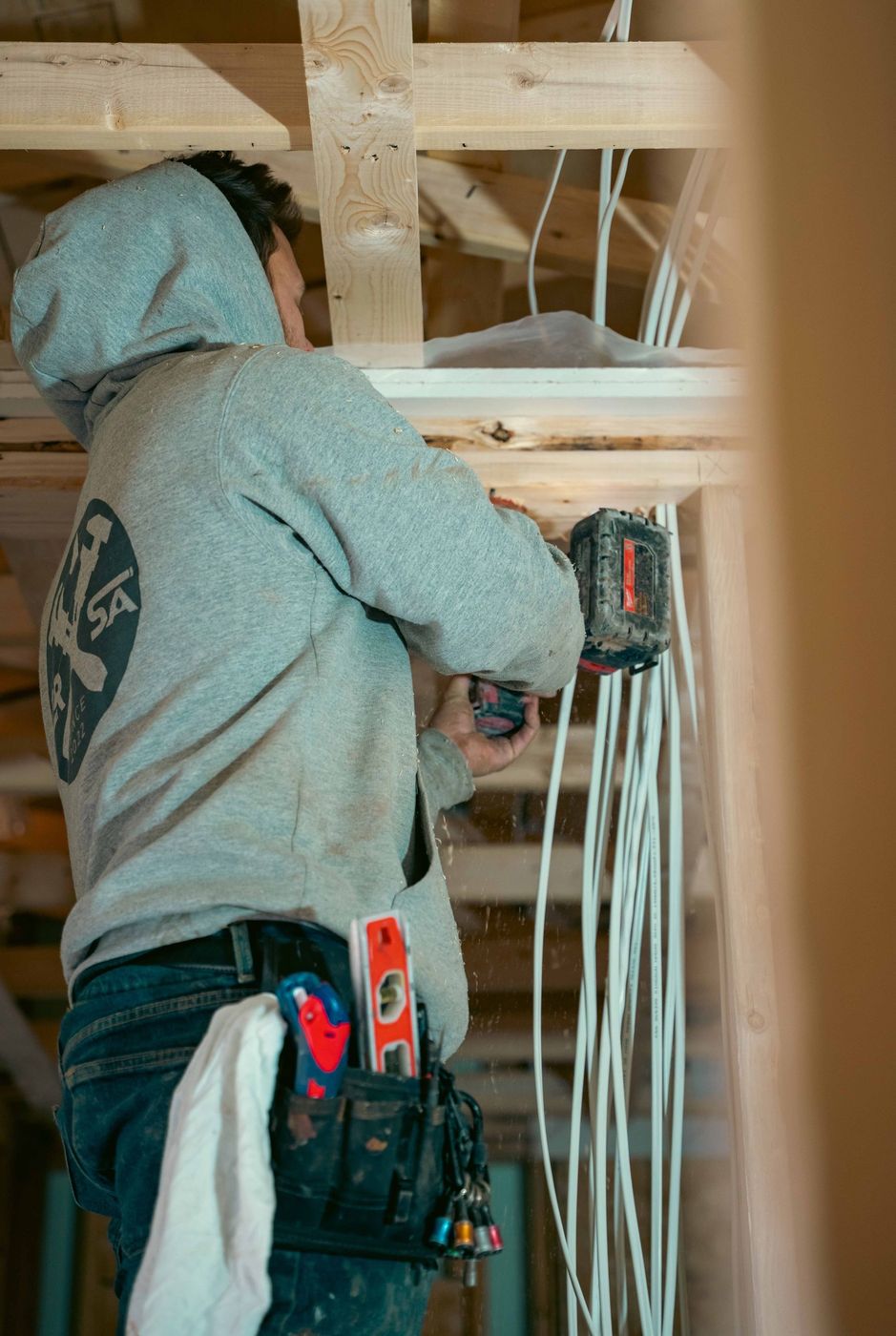 Plumber completing a plumbing rough-in inside a framed building
