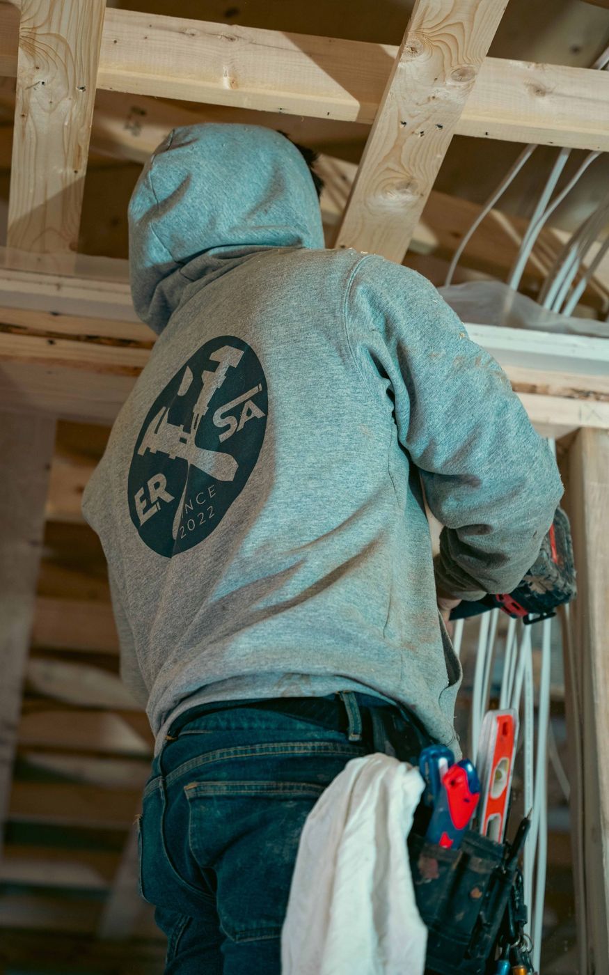 Plumber completing a plumbing rough-in inside a framed building