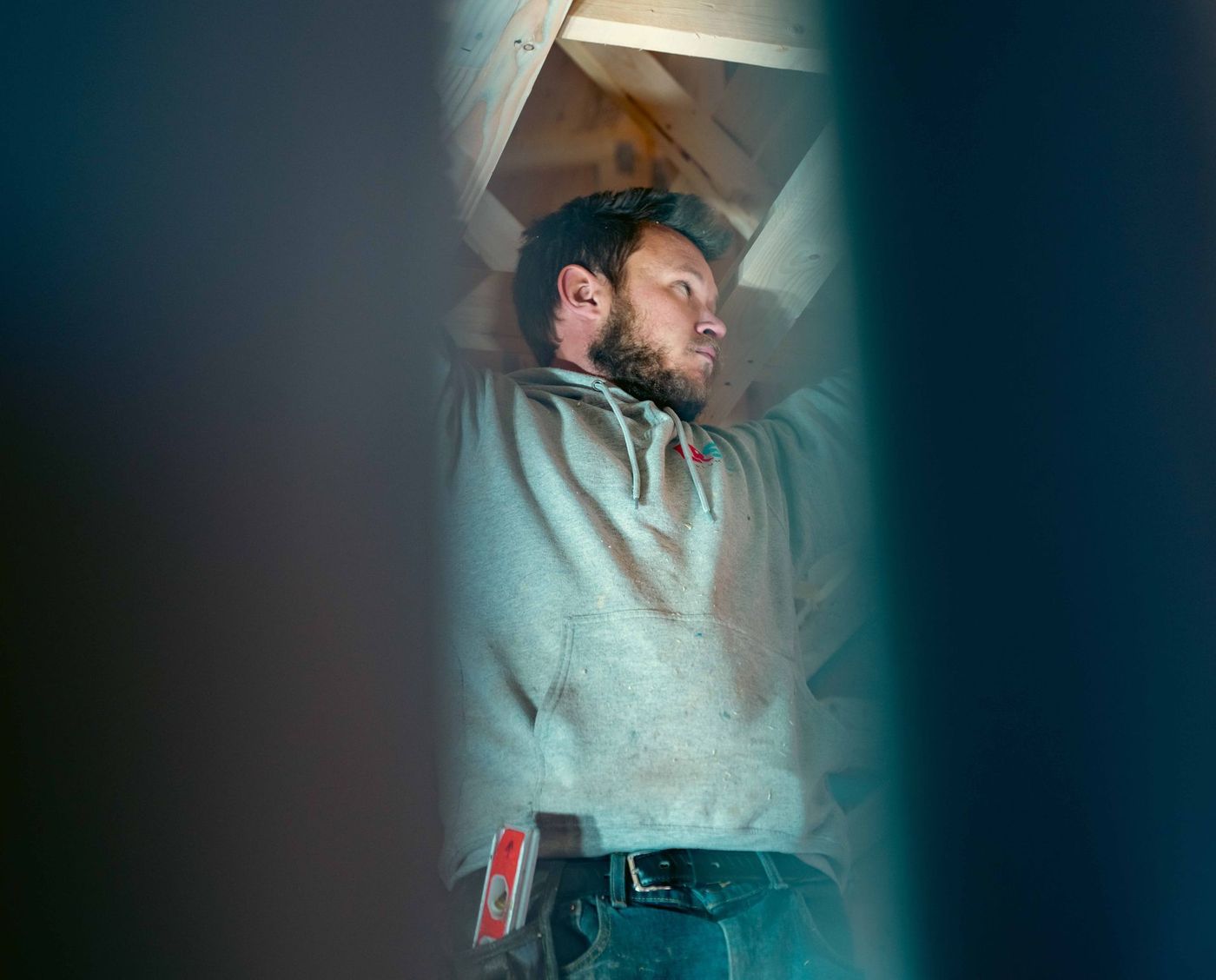 Plumber completing a plumbing rough-in inside a framed building